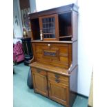 A MID VICTORIAN SIDE CABINET, THE GLAZED DOOR CENTRAL TO SHELVING ABOVE A FOUR PANELLED FALL FRONT