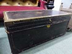 AN ANTIQUE BRASS EDGED AND CLOSE NAILED LEATHER COVERED CAMPHORWOOD TWO HANDLED TRUNK. W 93cms.