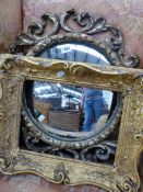 A CONVEX MIRROR IN OPOEN WORK GILT SCROLL FRAME. Dia. 57cms. TOGETHER WITH A SMALLER RECTANGULAR