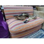 A SETTEE WITHOUT ARMS UPHOLSTERED IN ORANGE, RED AND BEIGE STRIPED MATERIAL
