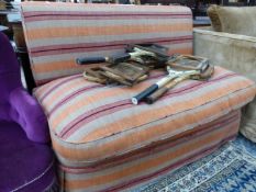 A SETTEE WITHOUT ARMS UPHOLSTERED IN ORANGE, RED AND BEIGE STRIPED MATERIAL