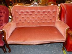 AN EDWARDIAN MAHOGANY SETTEE BUTTON BACKED IN PINK VELVET BELOW A TOP RAIL CENTRED BY AN ANTHEMION