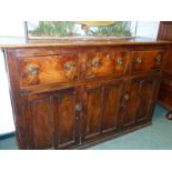 A 19th C. OAK AND ELM DRESSER BASE WITH THREE DRAWERS OVER TWO TWIN PANELLED DOORS AND A CENTRAL TW