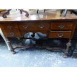 A MAHOGANY VENEERED WRITING TABLE, THE CROSS BANDED RECTANGULAR TOP OVER FIVE DRAWERS AND BALUSTER