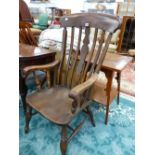 AN OAK KITCHEN ELBOW CHAIR WITH SHAPED PLATE FLANKED BY TWO BARS, THE SADDLE SEAT ON BALUSTER