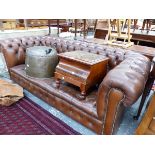 A BUTTONED BROWN LEATHER CHESTERFIELD ON BUN FEET. W 195cms.