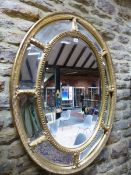 A MULTIPLE PLATE OVAL MIRROR IN A GILT FRAME, THE OUTER BATON BAND JOINED TO THE BEADED CENTRAL