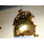 A SHAPED QUATREFOIL MIRROR IN GILT FOLIATE ROCOCO FRAME, FOUR LOOPED BRACKETS BELOW THE CRESTING