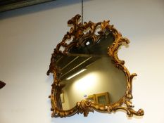 A SHAPED QUATREFOIL MIRROR IN GILT FOLIATE ROCOCO FRAME, FOUR LOOPED BRACKETS BELOW THE CRESTING