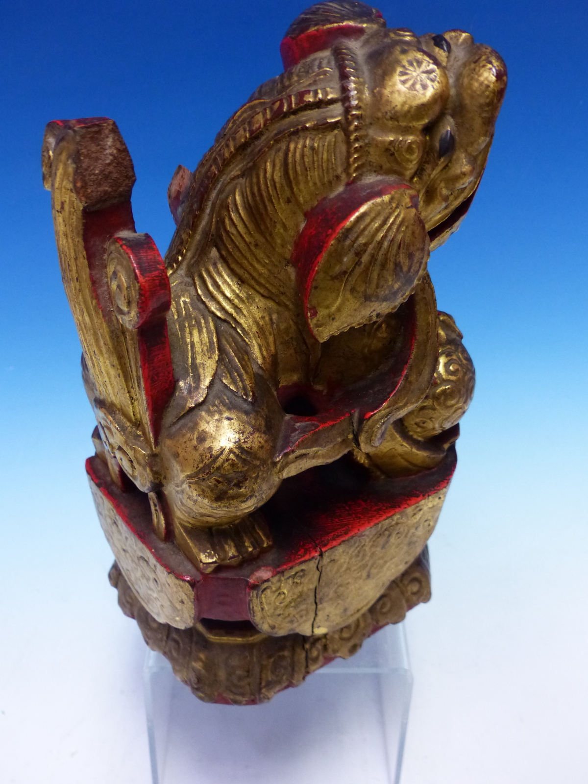 A CHINESE CARVED WOOD LION SEATED WITH A BROCADE BALL PARCEL GILT ON A RED LACQUER GROUND. H 23cms. - Image 3 of 5