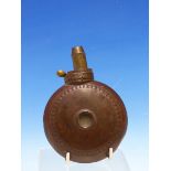 A ROUND COPPER POWDER FLASK WITH BRASS NOZZLE, A ROUNDEL RAISED TO EACH SIDE WITHIN A PELLET BAND.
