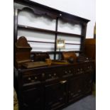 AN ANTIQUE OAK DRESSER WITH OPEN SHELF BACK, THE BASE WITH THREE DRAWERS ABOVE TWO CRUCIFORM PANELL