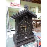A STAINED WOOD GOTHIC ORNAMENTED TWO TRAIN CUCKOO CLOCK STRIKING ON A COILED ROD. H 58cms.