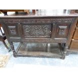 AN ANTIQUE OAK SIDE CABINET WITH FLORAL CARVED DOOR ABOVE THE BALUSTER LEGS JOINED BY A POT BOARD. W