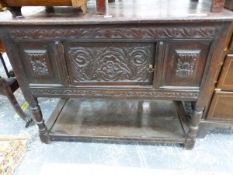 AN ANTIQUE OAK SIDE CABINET WITH FLORAL CARVED DOOR ABOVE THE BALUSTER LEGS JOINED BY A POT BOARD. W