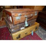 TWO LEATHER AND A LARGER VELLUM SUITCASE