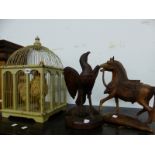A CARVED WOODEN HORSE AN EAGLE ON FISH CARVING AND AN ORNAMENTAL CHICKEN IN CAGE.