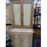 A PINE SIDE CABINET, THE TOP WITH GLAZED DOORS OVER SHELVES RECESSED ABOVE TWO PANELLED DOORS. W