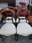 A MATCHED SET OF FOUR MAHOGANY BALLOON BACK CHAIRS, THE UPHOLSTERED SERPENTINE FRONTED SEATS ABOVE