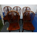 A SET OF FIVE OAK SADDLE SEATED WHEEL BACKED CHAIRS ON TURNED LEGS