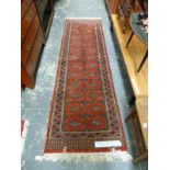 AN ORIENTAL RUNNER OF BOKHARA DESIGN 252 x 79cm