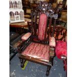 A STUART STYLE OAK ELBOW CHAIR CRESTED BY LIONS SUPPORTING A SHIELD ABOVE THE UPHOLSTERED BACK PAD