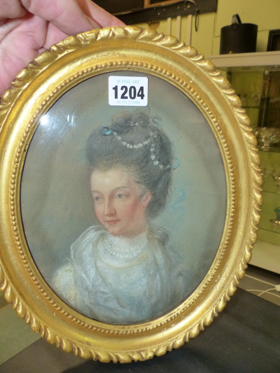 AN OVAL PASTEL PORTRAIT OF A GEORGIAN LADY WEARING PEARLS IN HER DARK HAIR, THE BACK INSCRIBED IN