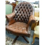 A BUTTONED LEATHER HOOP BACK DESK CHAIR ROTATING ON CRUCIFORM LEGS