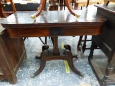 A REGENCY LINE INLAID MAHOGANY GAMES TABLE THE SWIVEL TOP ON A WAISTED SQUARE COLUMN, THE FOUR LEGS