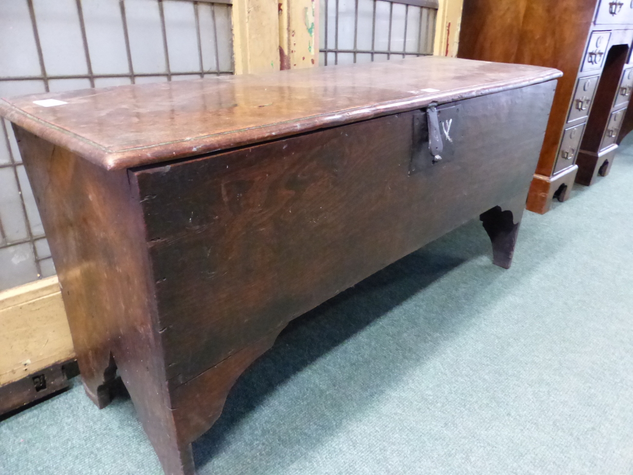 AN EARLY 18th C. OAK PLANK SIDED COFFER, THE NARROW SIDES CARVED WITH AN ARCH TO FORM THE LEGS AND - Image 2 of 4
