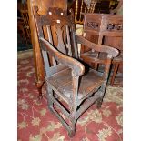 AN EARLY 18th C. OAK ELBOW CHAIR WITH WAVY TOP RAIL ABOVE THE CENTRAL BALUSTER SPLAT, THE SOLID SEAT