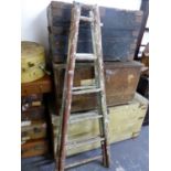 A RUSTIC A-FRAME PAINTED WOOD LADDER WITH SIX RUNGS ON ONE SIDE AND FIVE ON