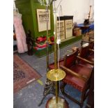 TWO BRASS STANDARD LAMPS ONE MOUNTED ONTO A CIRCULAR MAHOGANY BASE THE OTHER ON A TRIPOD
