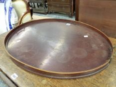 AN ANTIQUE BRASS HANDLED MAHOGANY OVAL TRAY, THE GALLERY RIM WITH LINE INLAY. 77 x 55cms.