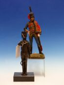 A BRONZE FIGURE OF A MILITARY TRUMPETER STANDING ON A BLACK STONE BASE. H 28cms. TOGETHER WITH AN