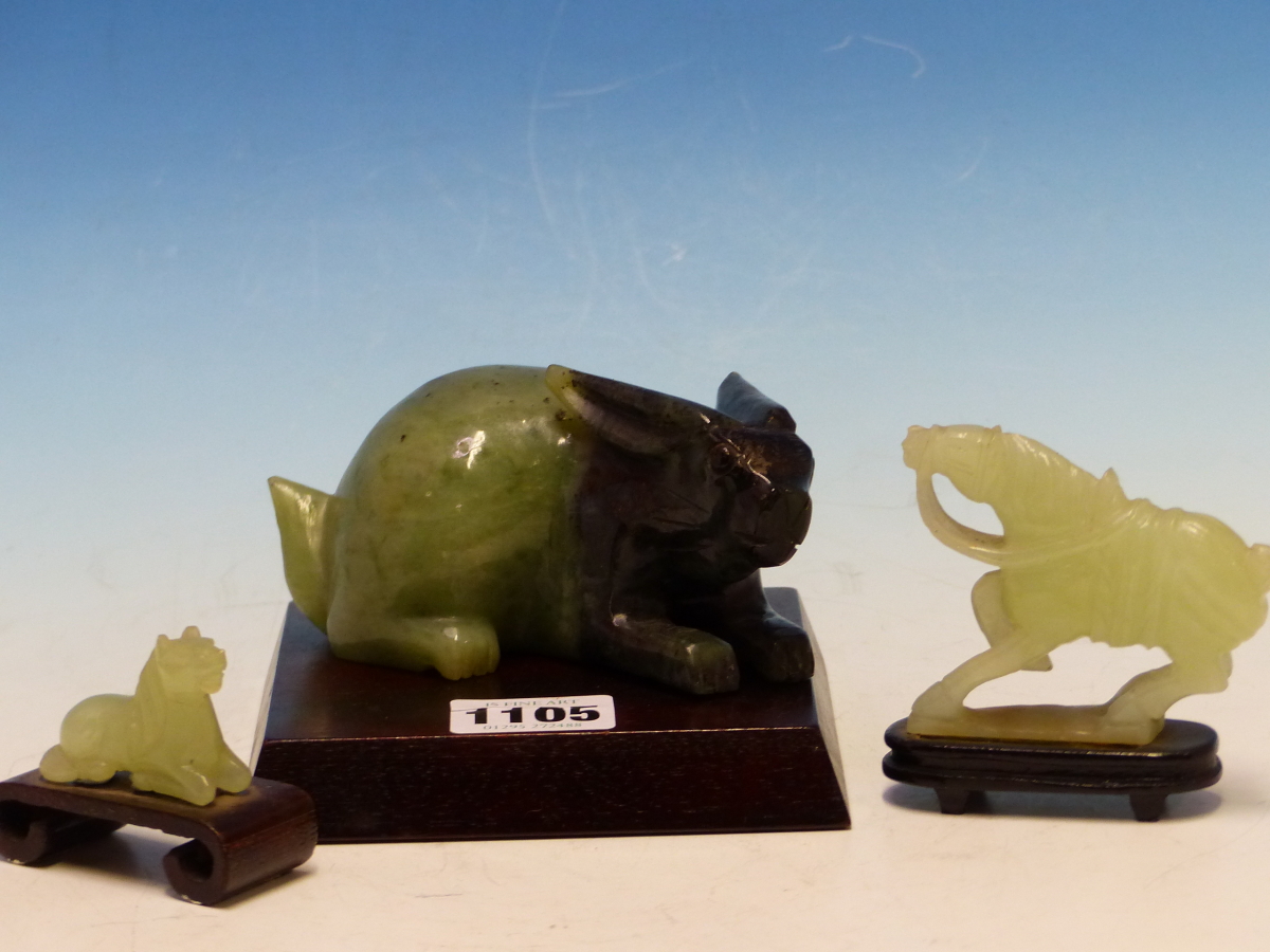 A CHINESE GREEN AND BLACK BOWENITE CARVING OF A RABBIT. W 13cms. TOGETHER WITH TWO GREEN STONE