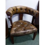 A BUTTONED LEATHER OAK DESK CHAIR WITH THE HALF ROUND BACK RUNNING INTO THE ARMS, THE SEAT ON