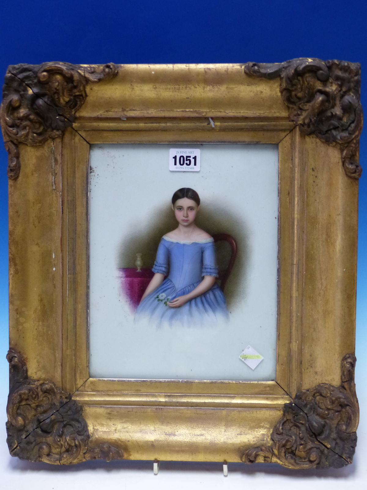 A GILT FRAMED PORTRAIT OF A DARK HAIRED GIRL ON MILK GLASS, SIGNED S CHESTERS 1848, SHE SITS BY A