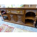 A VICTORIAN WALNUT SIDEBOARD CARVED WITH FOLIAGE SCROLLS ABOUT MASKS, THE CENTRAL DRAWER OVER TWO