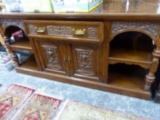 A VICTORIAN WALNUT SIDEBOARD CARVED WITH FOLIAGE SCROLLS ABOUT MASKS, THE CENTRAL DRAWER OVER TWO