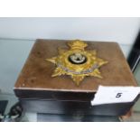 AN OXFORDSHIRE LIGHT INFANTRY GILT AND SILVER BADGE MOUNTED UPON A JEWELLERY BOX.