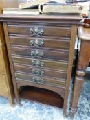 AN EADWARDIAN MAHOGANY MUSIC CABINET WITH SIX DRAWERS ABOVE AN OPEN SHELF