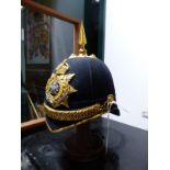A BLUE CLOTH MANCHESTER REGIMENT HELMET WITH CHIN STRAP AND SPIKE FINIAL.