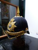 A BLUE CLOTH MANCHESTER REGIMENT HELMET WITH CHIN STRAP AND SPIKE FINIAL.