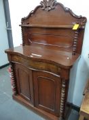 A VICTORIAN SERPENTINE FRONTED MAHOGANY CHIFFONIER SIDE CABINET, THE BACK WITH A FOLIATE CARVED TOP