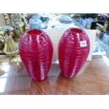 A PAIR OF RED GLASS VASES.