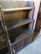 A SMALL OAK BOOKCASE WITH CABINET BASE.