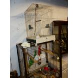 A VINTAGE BIRD CAGE AND A MODERN PARROT CAGE