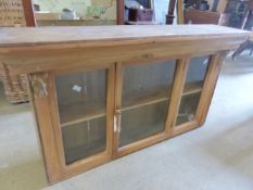 A PINE GLAZED WALL CABINET.