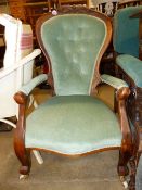 AN ANTIQUE BUTTON BACK ARMCHAIR